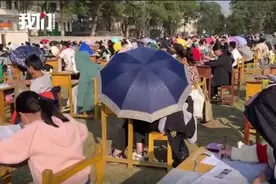 湖南一学校试行在操场上进行期中考试，有学生因太晒撑伞参加图片