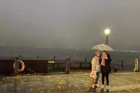 寒潮来袭 | 断桥边，西湖畔，雪花飞舞，夜游的人们纷纷举伞留影图片