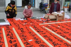 江西遂川：少年兄妹俩街头摆摊写春联 书法出色引围观图片