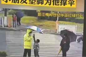 雨中踮脚为执勤交警撑伞 小男孩获赞“最美少年”图片