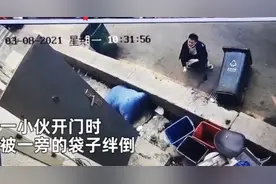 小伙开门瞬间被绊倒，反向“倒栽葱”后单手撑地，蹲在地上自己都笑了图片