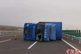 新疆三十里风区10级大风刮翻厢式货车 交警营救司机脱险图片