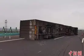 新疆三十里风区10级大风刮翻厢式货车 交警营救司机脱险图片