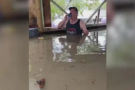 暴雨引发洪水房子被淹 澳大利亚男子坐在洪水里淡定喝啤酒图片