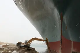 埃及运河搁浅巨轮旁“渺小”挖掘机的工人：面对梗图笑不起来图片