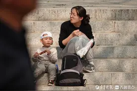 千佛山公园庙会上，一名小朋友吃着糖葫芦图片