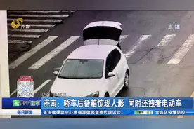 奇葩操作！济南街头一轿车后备厢大敞，人坐上面手里还拽着电动车视频封面
