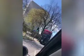 愚蠢！英国一年轻男子抓在公交车后冒险 摇摇晃晃保持平衡图片