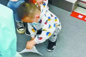 好家教！水壶掉在地铁车厢 两岁萌娃蹲下擦拭图片