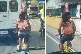 菲律宾一女子头顶一瓶水“大撒把”骑自行车 平衡性令人惊讶图片