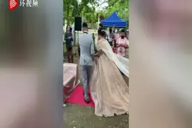 菲律宾一婚礼策划师藏在新娘婚纱下面 帮她整理裙子方便行走图片