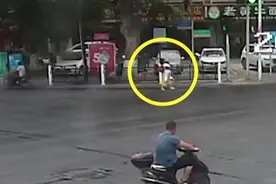 老人站在马路中间双腿发抖不能走路 热心女子“熊抱”将其送到对面图片