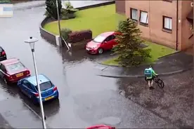 英国一名外卖员脱下鞋袜趟过被洪水淹没的街道送餐获赞图片