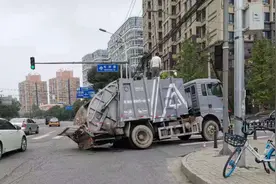 雨后北京海淀区一路口路面塌陷，环卫垃圾车左后车轮深陷坑中图片
