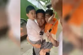 风雨中无伞老人用身体护着两个孩子 小伙送上伞抱起两个孩子送回家图片