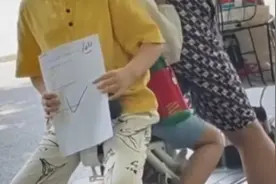 小男孩手举100分试卷坐电动车上一路炫耀 网友：这很凡尔赛啊！视频封面