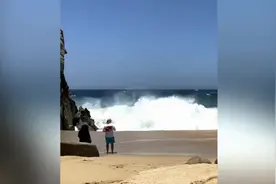 墨西哥海滩三名游客靠近大海拍照 被巨大海浪打翻在地图片