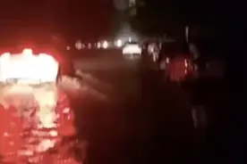 河南暴雨，路面积水严重孩子冒雨拦车，提醒车辆停止继续前行图片
