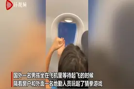 机场工作人员隔窗与等待起飞的男童玩游戏 反应可爱图片