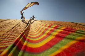 印尼工人山坡上晾晒彩色布匹 好似彩虹从天而降图片