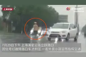 上海外卖小哥暴雨中指挥交通，网友：加工资图片