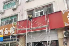 济南一女子因家庭纠纷爬上五米高脚手架 消防员飞身救下图片