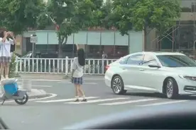 女孩趴在斑马线上让同伴拍照图片