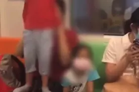 上海一男孩在地铁上爬扶手杆荡秋千，家长不制止，还鼓励他往上爬图片