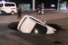 郑州市区一轿车掉进路中大坑，车内人员爬出图片