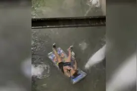 纽约男子暴雨中躺在浮垫上 在被淹没的街头边漂浮边抽水烟图片
