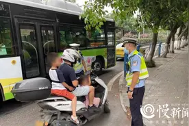 脚下夹一个背上捆一个 父亲骑车违规载娃被拦下图片