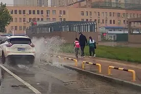 菏泽一辆白色轿车，经过积水路段不减速，行人遭“飞来横祸”！图片