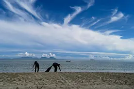 印度尼西亚志愿者在海滩捡拾垃圾保护生态环境图片