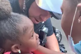 美国黑人小孩被吓哭问“你要开枪打我们吗”，白人警察搂住她安慰图片
