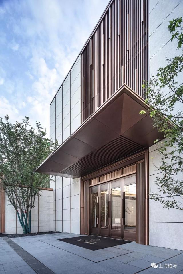 的品性,主入口的玻璃与仿铜铝板相得益彰,大尺度的挑檐具有厚重严肃感