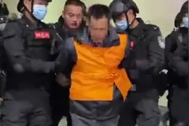 A级逃犯张承禹被荷枪实弹押解画面曝光：身穿橙黄色马甲 双脚戴脚镣图片