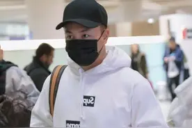 释小龙现身机场，白色连帽卫衣配迷彩工装裤，散发硬汉魅力图片