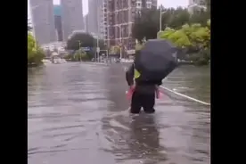 车辆遇积水熄火 交警背孩子淌过路口图片