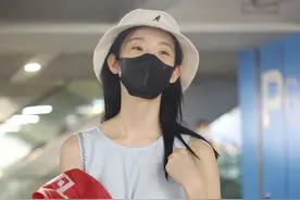 张艺凡戴渔夫帽和口罩遮面，身穿连衣裙，蹲下来暖心哄小粉丝图片