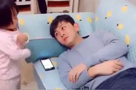 爸爸玩手机，1岁儿子凑过来还一直摇头，接下来举动让爸爸笑抽了图片