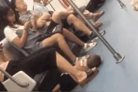 地铁里一男孩睡地板上，妈妈却悠闲玩手机，看到孩子手后乘客报警图片