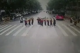 萌化了！幼儿园小朋友过斑马线一起向让行公交司机挥手致谢图片