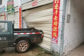 司机空挡停车手刹失灵，皮卡后溜撞坏商铺大门图片