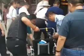 69岁洪金宝坐轮椅逛古镇，需两人搀扶上台阶，小13岁妻子保养好图片