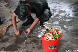 抗洪一线武警战士转换营地，走前用手捧走最后一点垃圾​图片
