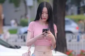 小姐姐粉色的紧身T恤搭配一条牛仔超短裤，尽显时尚风范图片