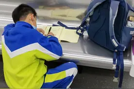 地铁上做作业的小学生：做完到家就能直接玩游戏了图片
