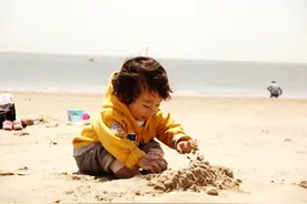 带孩子去沙滩玩沙，宝宝脚丫全程不沾地，网友：肯定被沙子烫过图片