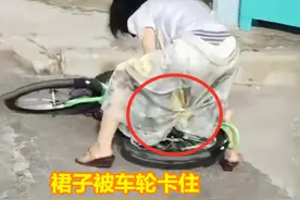 河北：女子穿裙子骑车，结果卡车轮摔倒，半蹲拉扯差点把裙子拽掉图片