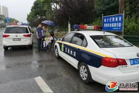 怎么回事？岳阳这几名“制服男”雨中给路口轮椅上的老人撑伞图片